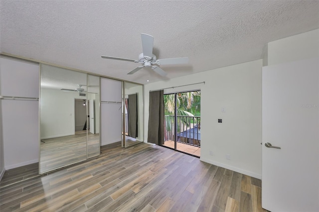 2627 2nd Ct, Palm Harbor, FL 34684 - unfurnished bedroom with a textured ceiling, baseboards, light wood-style flooring, and access to exterior