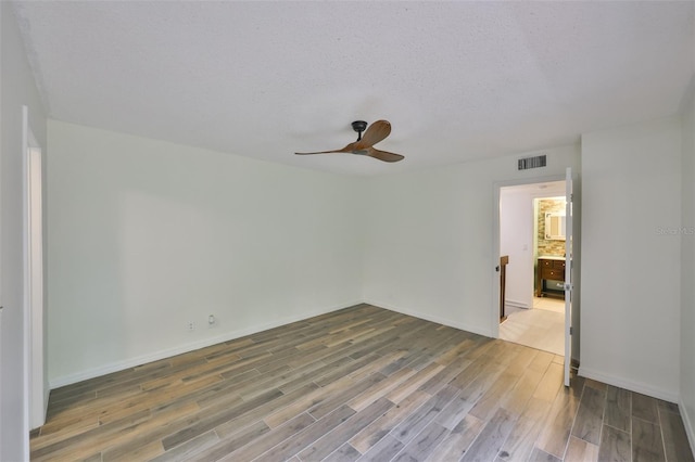 2627 2nd Ct, Palm Harbor, FL 34684 - empty room with ceiling fan, a textured ceiling, visible vents, wood finished floors, and baseboards