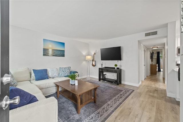 living room with baseboards, light wood-style flooring, and visible vents