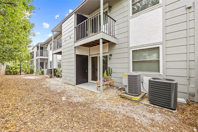 rear view of property featuring central AC unit and a balcony