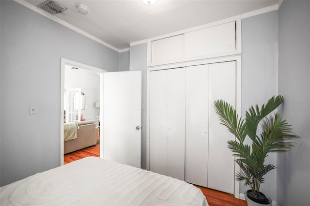2235 Burlington Ave N, Saint Petersburg, FL 33713 - bedroom with a closet, visible vents, ornamental molding, and light wood-style floors