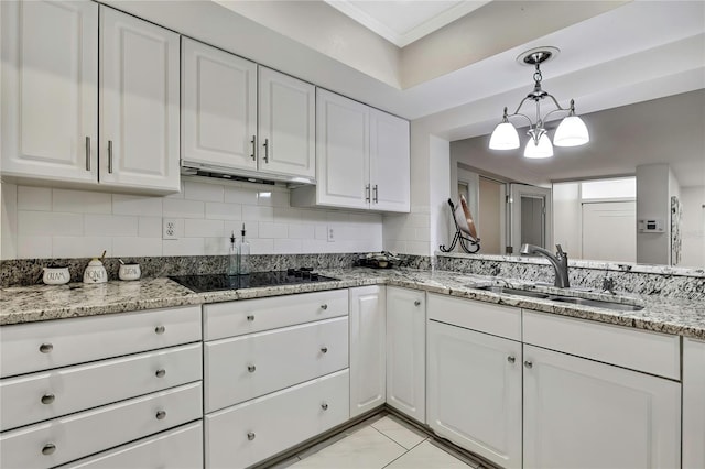 4175 Northmeadow Cir Unit 4175, Tampa, FL 33618 - kitchen with black electric cooktop, a sink, white cabinetry, a chandelier, and backsplash