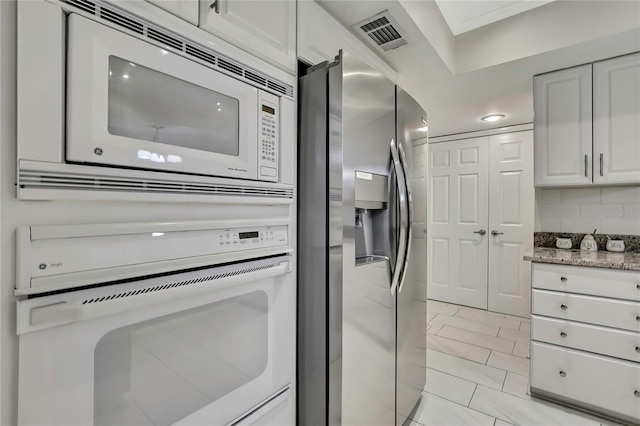 4175 Northmeadow Cir Unit 4175, Tampa, FL 33618 - kitchen featuring white appliances, light stone countertops, white cabinets, and decorative backsplash