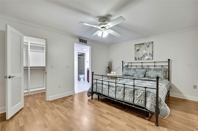 4175 Northmeadow Cir Unit 4175, Tampa, FL 33618 - bedroom featuring ornamental molding, wood finished floors, baseboards, a spacious closet, and ensuite bathroom