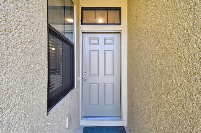 entrance to property with stucco siding