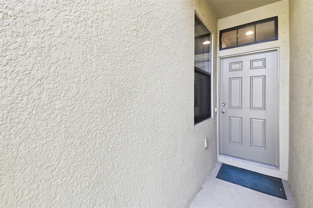 view of exterior entry featuring stucco siding