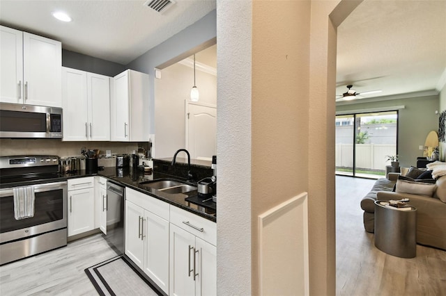 kitchen featuring stainless steel appliances, visible vents, a sink, and light wood-style flooring