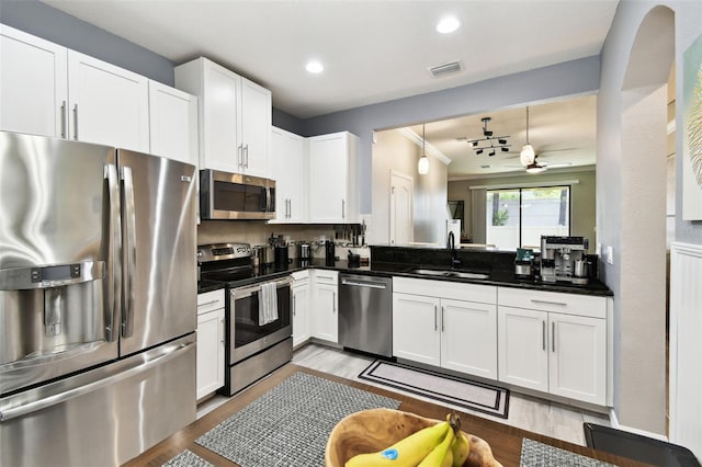 kitchen featuring a sink, light wood-style flooring, stainless steel appliances, a ceiling fan, and visible vents