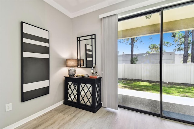 doorway with crown molding, baseboards, and wood finished floors