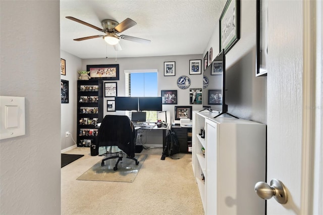 carpeted office with a ceiling fan