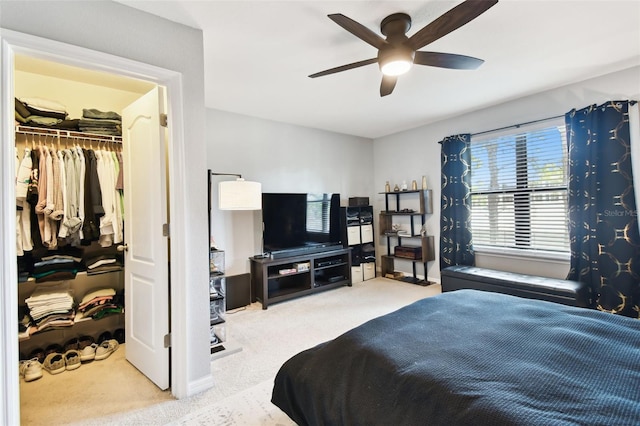 carpeted bedroom featuring ceiling fan, a spacious closet, and a closet