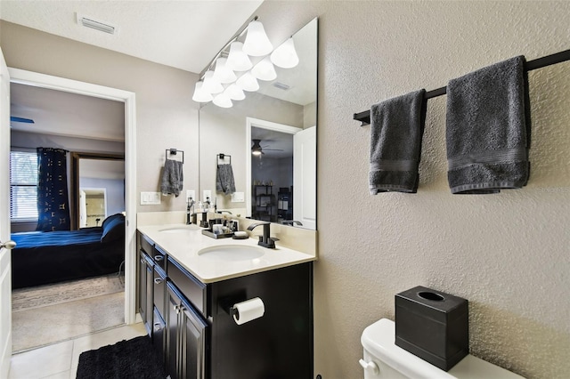 full bathroom featuring visible vents, a textured wall, tile patterned floors, a sink, and ensuite bath