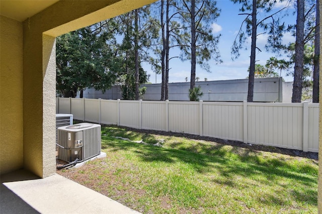 view of yard with central air condition unit and a fenced backyard