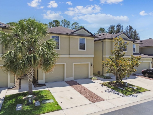 view of front of property featuring an attached garage, driveway, and stucco siding