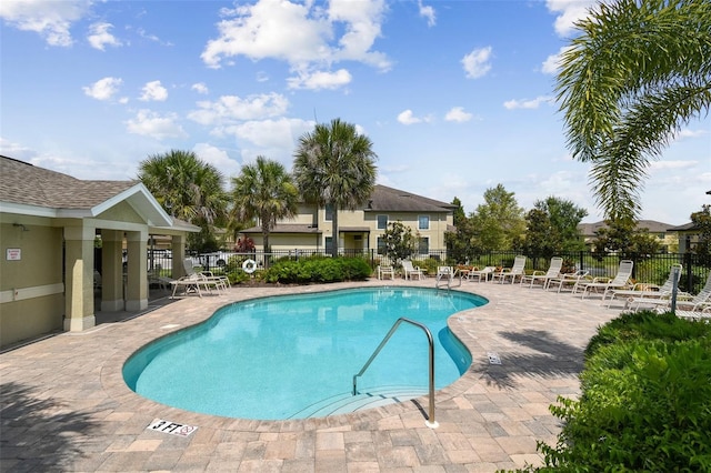 pool with fence and a patio