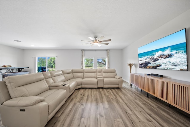 7797 Peace Lily Ave, Wesley Chapel, FL 33545 - living area featuring light wood-type flooring, baseboards, visible vents, a ceiling fan, and a textured ceiling