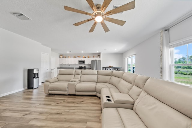 7797 Peace Lily Ave, Wesley Chapel, FL 33545 - living area featuring visible vents, a healthy amount of sunlight, ceiling fan, and light wood-style flooring