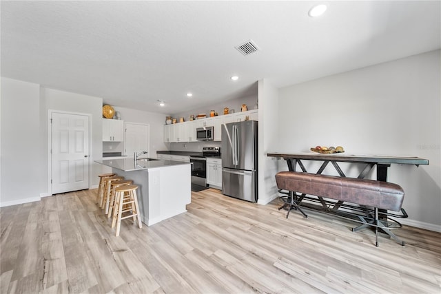 7797 Peace Lily Ave, Wesley Chapel, FL 33545 - kitchen featuring a sink, a breakfast bar, visible vents, appliances with stainless steel finishes, and an island with sink