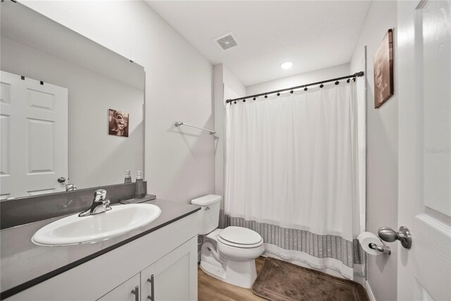 7797 Peace Lily Ave, Wesley Chapel, FL 33545 - full bath featuring visible vents, wood finished floors, toilet, and vanity