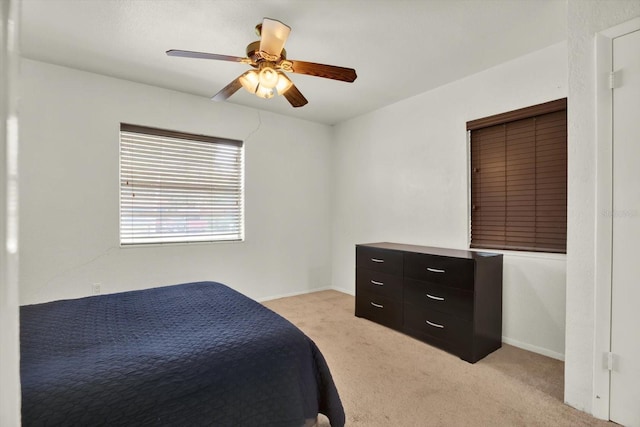 bedroom with light colored carpet, baseboards, and ceiling fan