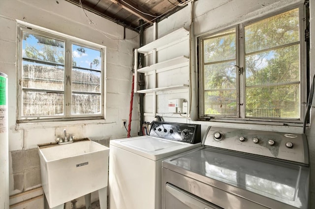 laundry room featuring washer and clothes dryer, laundry area, a sink, and concrete block wall