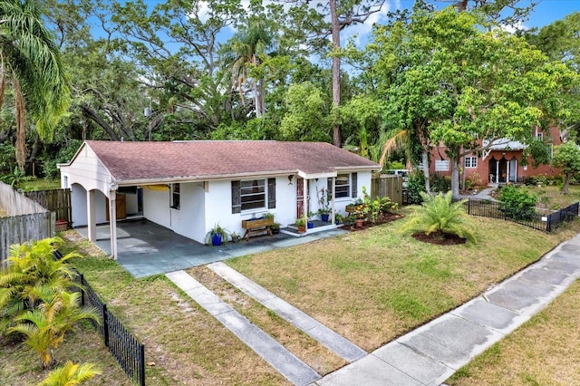 view of front of house with a front yard, stucco siding, an attached carport, and driveway