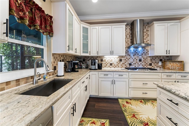2701 W Bay Ave, Tampa, FL 33611 - kitchen with decorative backsplash, stainless steel gas cooktop, a sink, white cabinets, and wall chimney exhaust hood