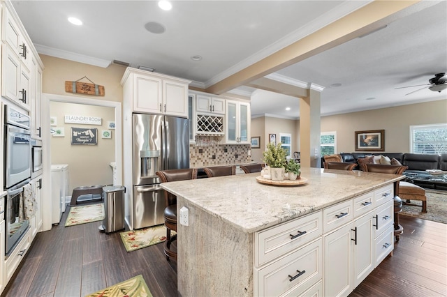 2701 W Bay Ave, Tampa, FL 33611 - kitchen featuring decorative backsplash, dark wood-style flooring, a center island, light stone counters, and stainless steel appliances