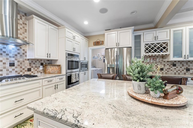 2701 W Bay Ave, Tampa, FL 33611 - kitchen with ornamental molding, backsplash, stainless steel appliances, and wall chimney exhaust hood