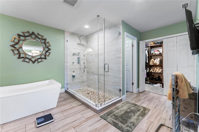2701 W Bay Ave, Tampa, FL 33611 - full bathroom with visible vents, wood tiled floor, and a stall shower