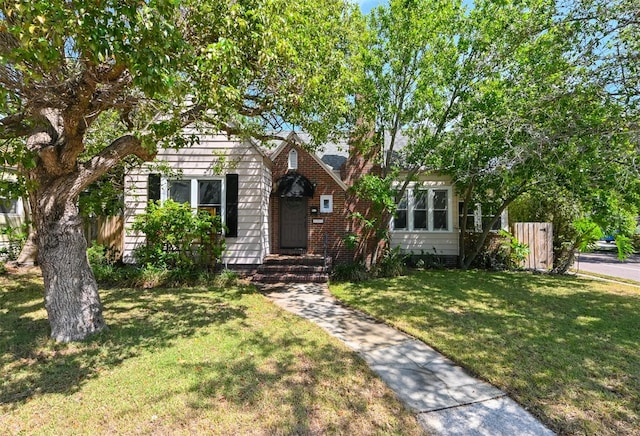 obstructed view of property with fence and a front lawn