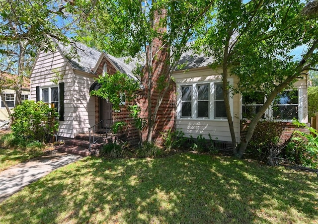 view of front facade featuring a front lawn and roof with shingles