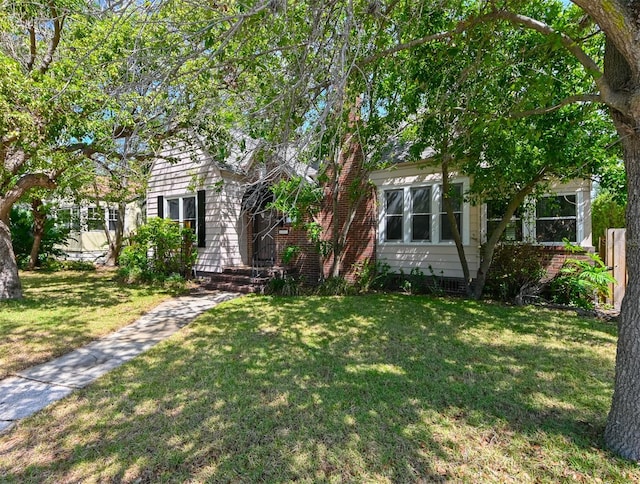 view of property hidden behind natural elements with a front yard