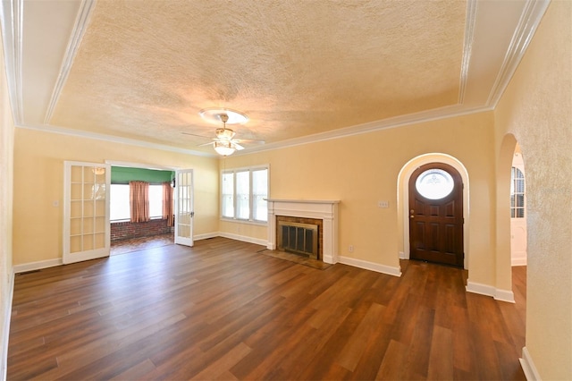 unfurnished living room featuring crown molding, arched walkways, and a textured ceiling