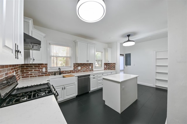 kitchen with a sink, light countertops, stainless steel dishwasher, and under cabinet range hood