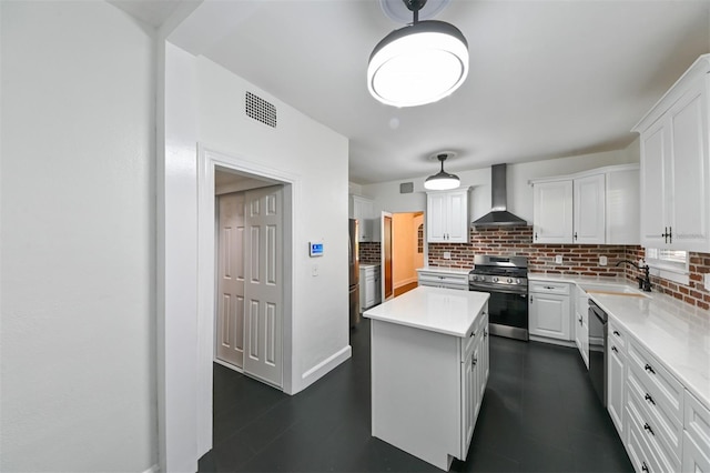 kitchen featuring backsplash, a sink, wall chimney exhaust hood, and gas range