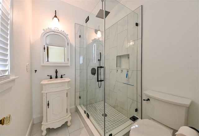 full bathroom featuring vanity, a stall shower, toilet, and a wealth of natural light