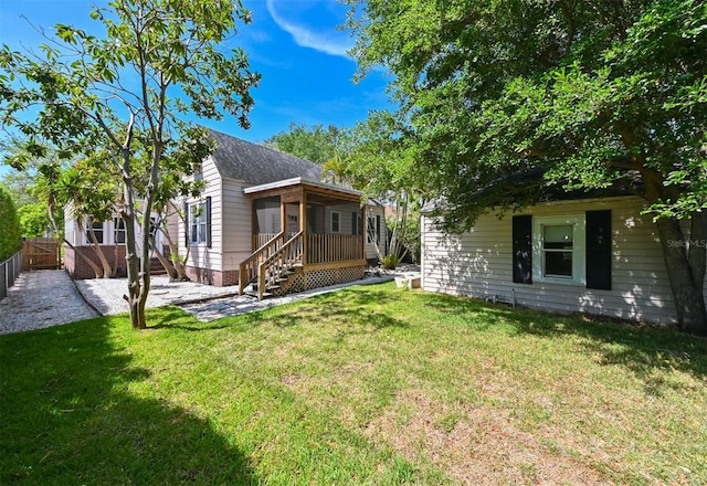 rear view of house with a lawn and fence
