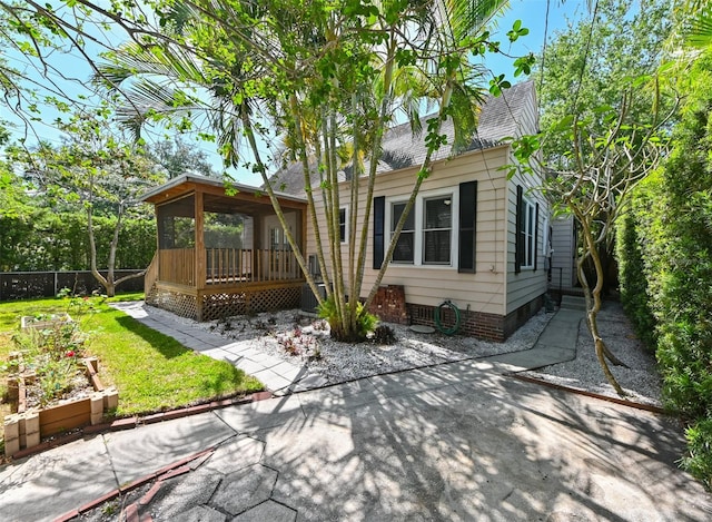 back of property with fence, a wooden deck, a yard, and roof with shingles