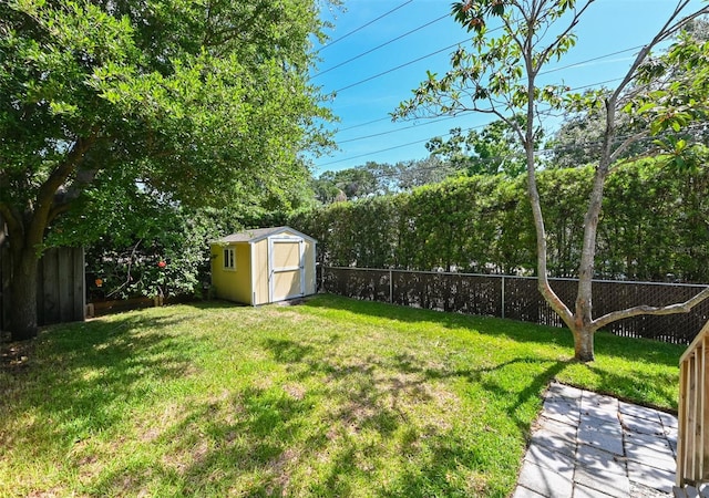 view of yard featuring an outbuilding, a shed, and a fenced backyard