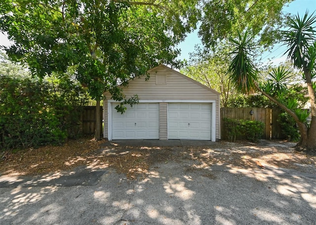 detached garage featuring fence