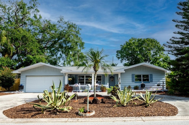 ranch-style house with a porch, a garage, and driveway