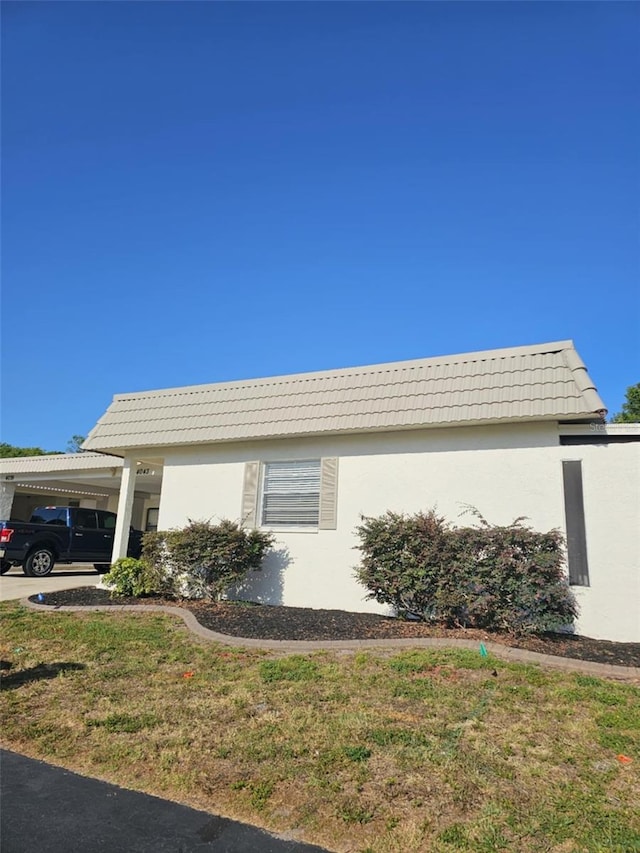 4043 La Pasida Ln, New Port Richey, FL 34655 - view of front of house with a tile roof, a front yard, a carport, and stucco siding