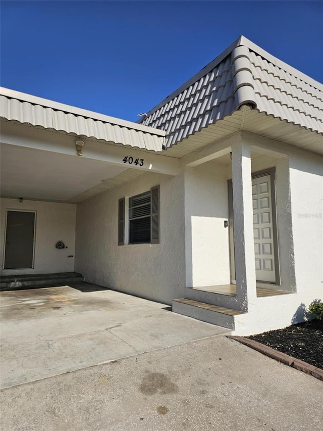4043 La Pasida Ln, New Port Richey, FL 34655 - doorway to property featuring a carport and stucco siding