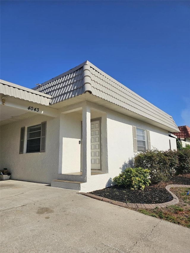 4043 La Pasida Ln, New Port Richey, FL 34655 - property entrance with stucco siding and mansard roof
