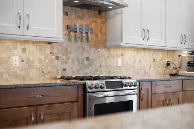 kitchen featuring gas range, ventilation hood, white cabinets, tasteful backsplash, and light stone counters