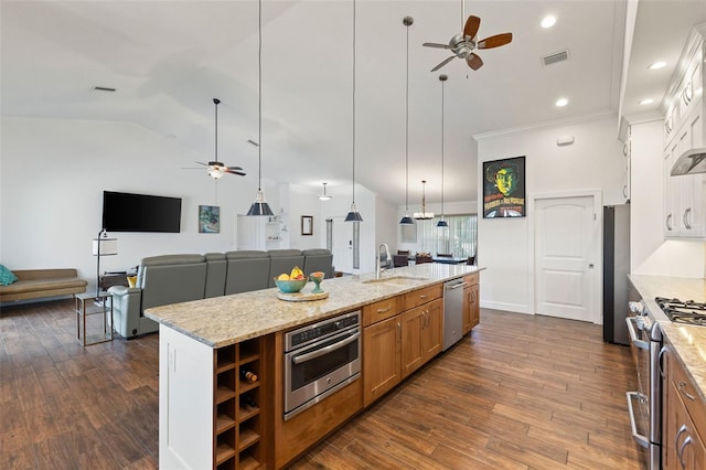 kitchen with brown cabinets, a ceiling fan, a sink, and stainless steel appliances