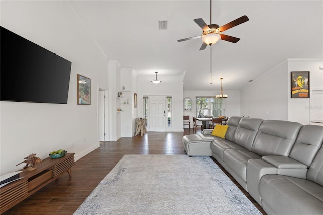 living area with crown molding, dark wood-style flooring, ceiling fan with notable chandelier, lofted ceiling, and visible vents
