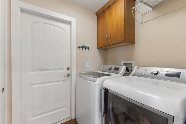 laundry area featuring cabinet space, separate washer and dryer, and a textured ceiling