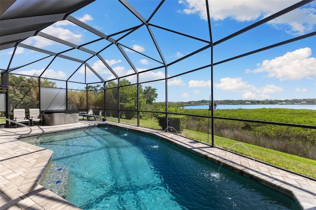 outdoor pool with a patio, a water view, and glass enclosure
